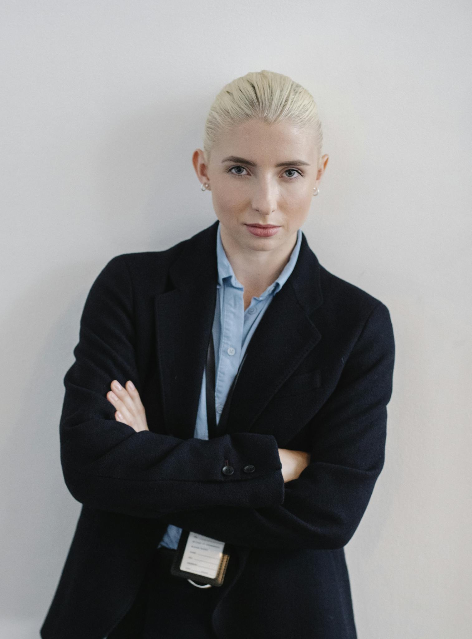 Professional businesswoman standing confidently with arms crossed in an office setting.